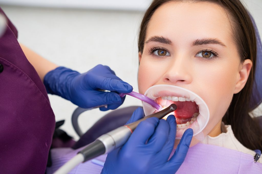 Dentist examining a patient’s gums for signs of gum disease in Leawood, KS