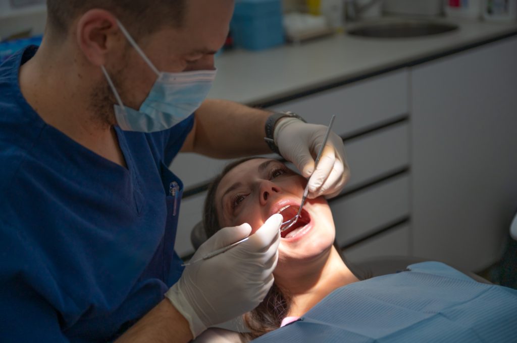 Dentist examining a patient’s gums for signs of gum disease in Leawood, KS